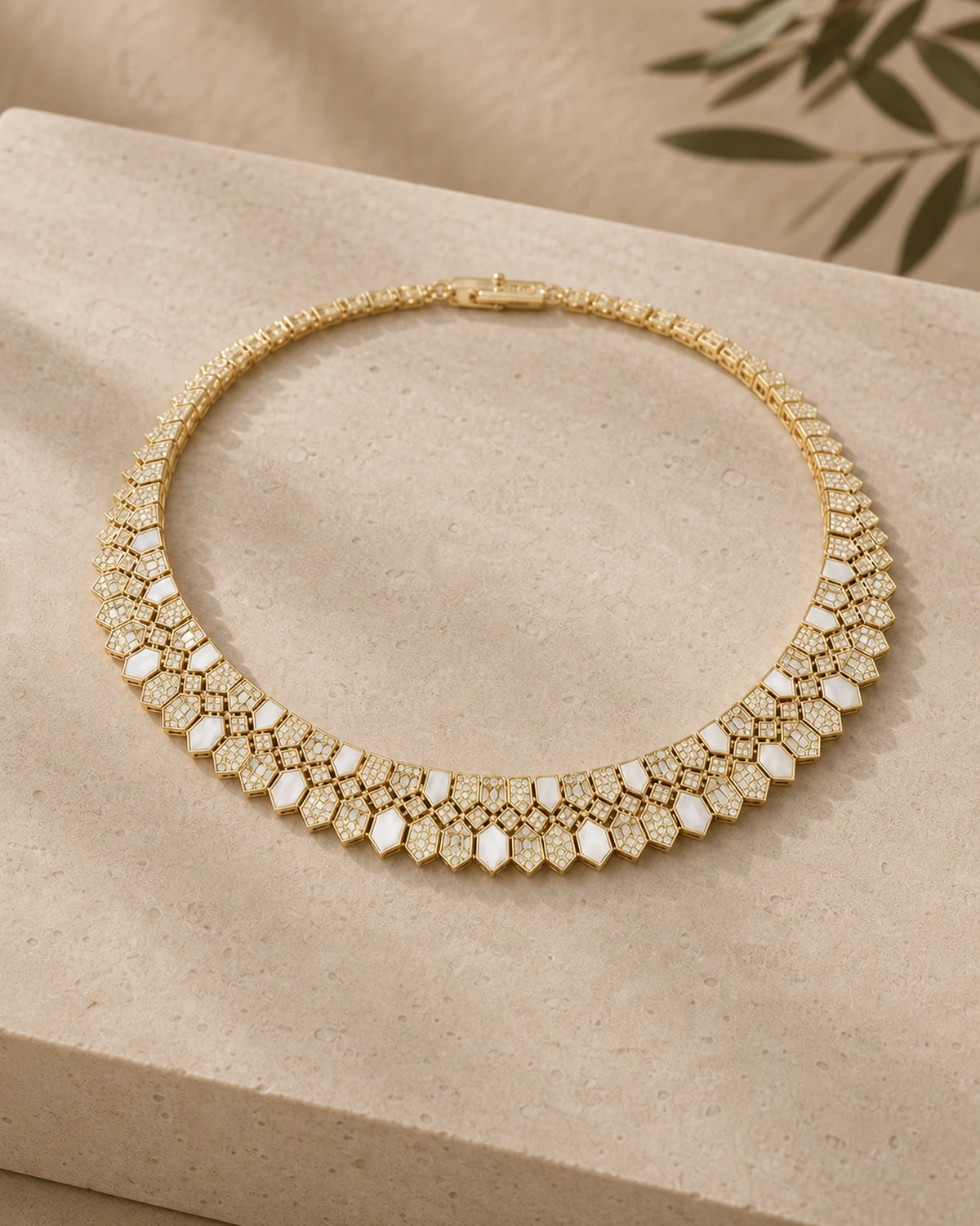 Close catalogue view of Lucilla's linked polygon collar, alternating pale opaque and densely textured faces along its tapered lower fringe.