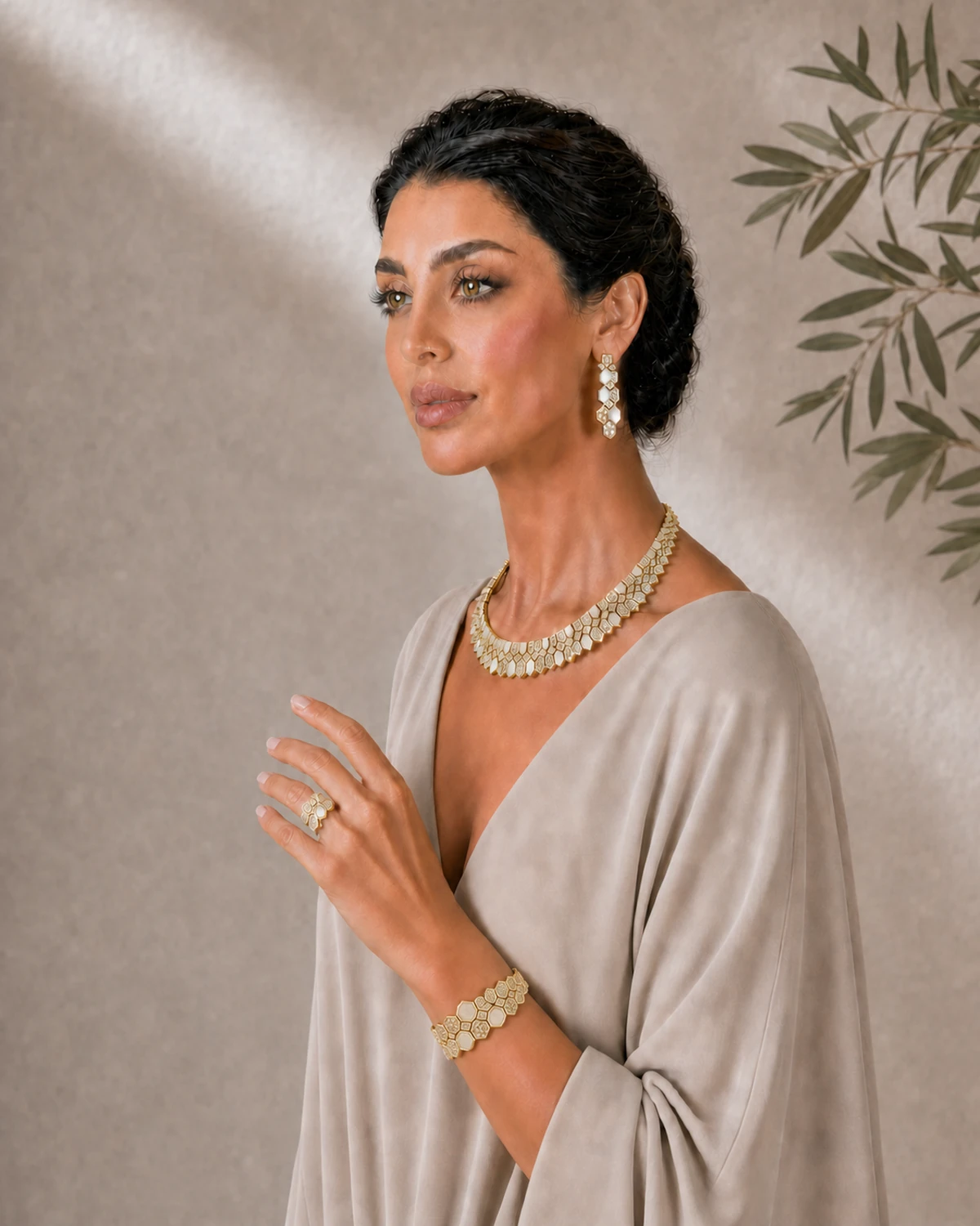 Luna in a turned one-hand component pose, wearing the Lucilla clustered ring and the same articulated geometric link bracelet naturally wrapped around the wrist with the collar and earrings.